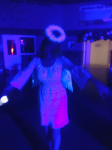 Megan Palmer dressed as an angel at the halloween dance. Palmer is glowing under the black light.