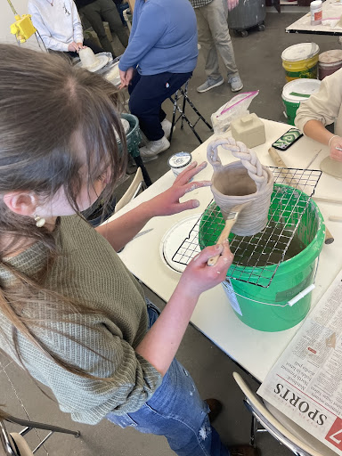 Webb glazing her coil pot. She made her coil pot into a basket with a braided handle.