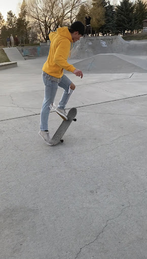 Skater at the park hitting a kickflip
