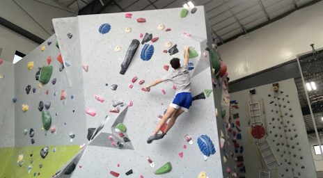 Fisher Anderson jumping for a rock climbing hold. 
